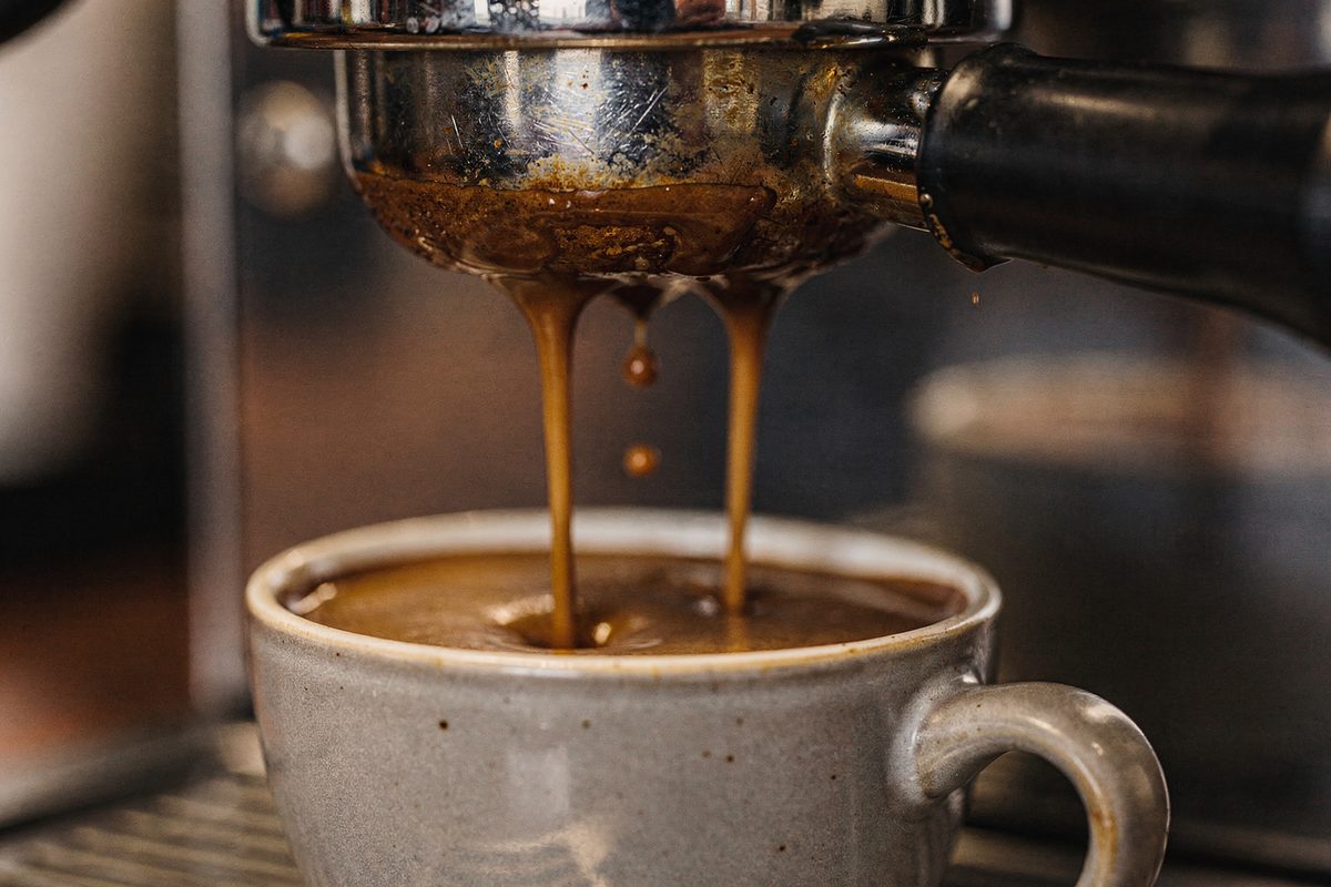 Macro view of twin streams of espresso flowing into an espresso cup